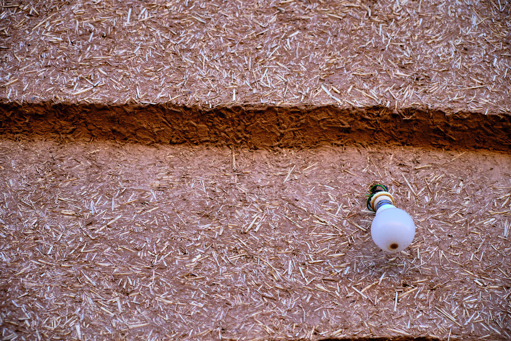 Lehm-Strohwand mit einer Glühbirne | Tafraoute, Marokko - November 21, 2024: Lehm-Strohwand mit einer Glühbirne. - Realisiert mit Pictrs.com