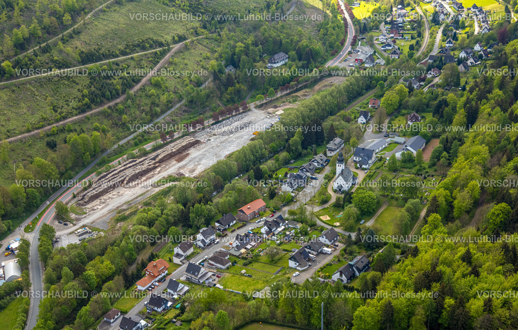 Brilon240503731 | Luftbild, Holzlagerplatz an der Bundesstraße B251, Wohngebiet mit St. Joseph Kirche Brilon-Wald und Friedhof Gräberfeld, Kita Kindergarten Die Waldwichtel und Alte Schule Gemeindezentrum, hinten links Mehrfamilienhaus Korbacher Straße 22 Bundesstraße B251, Brilon-Wald, Brilon, Sauerland, Nordrhein-Westfalen, Deutschland