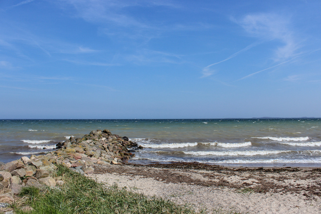 Wandbild: Wellen am Ostseestrand | Dieses Wandbild im Querformat zeigt den Strand in Norgaardholz. Am Himmel sind nur einige Schleierwolken zu sehen.  - Realisiert mit Pictrs.com