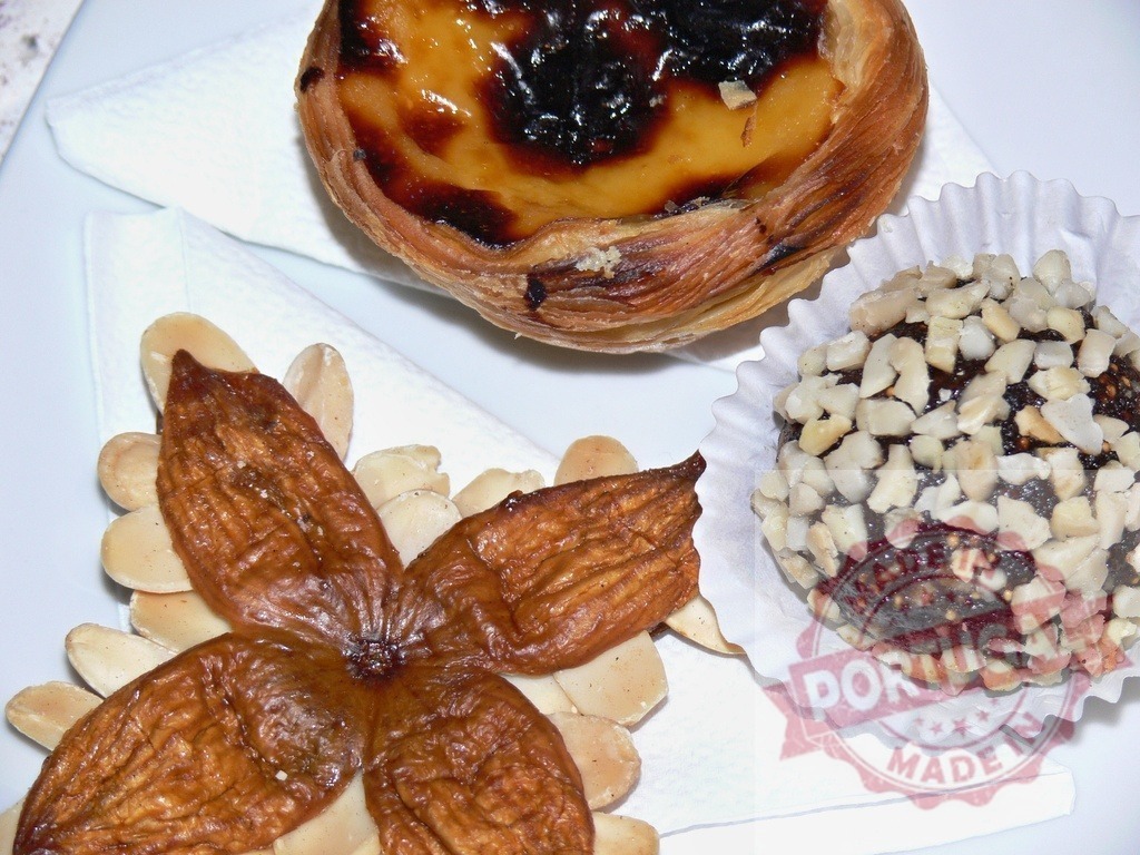 Pastel de nata, dried figs and energy ball making a delicious dessert composition | Traditional portuguese sweets, pastel de nata, dried figs and energy ball, served on a white plate - Realisiert mit Pictrs.com