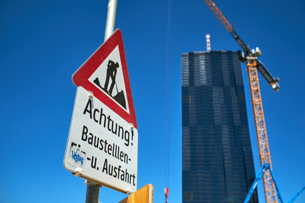 Tafel mit Achtung Baustellausfahrt vor einem Hochhaus mit Hochkran | Wien, Austria - June 02, 2021: Tafel mit Achtung Baustellausfahrt vor einem Hochhaus mit Hochkran. - Realisiert mit Pictrs.com