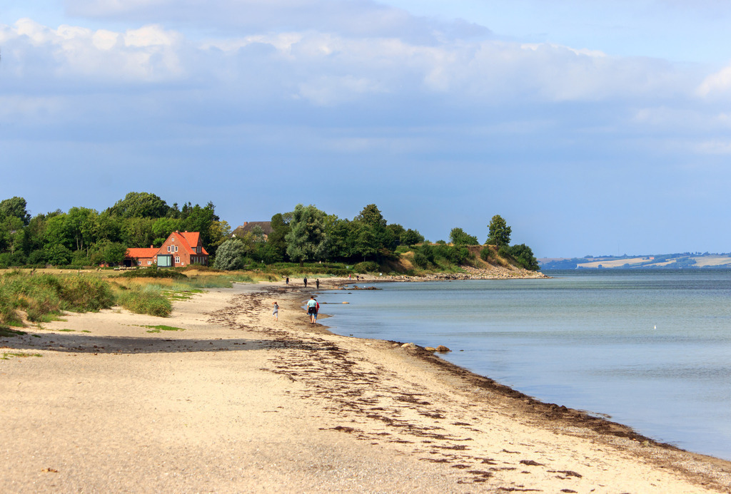 Wandbild: Strand in Norgaardholz | Dieses Wandbild im Querformat zeigt den schönen Sandstrand in Norgaardholz. In der Ferne ist die Steilküste zu sehen. Am Himmel befinden sich zahlreiche Wolken. - Realisiert mit Pictrs.com