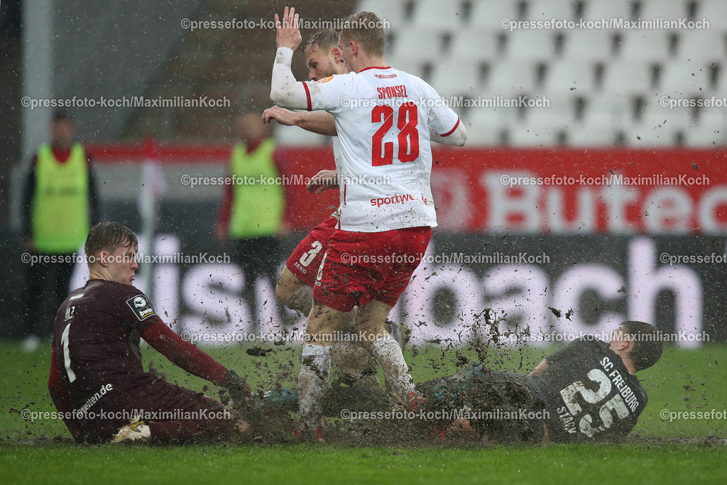 RWE3Liga01042301038 | 01.04.2023, Essen, Fußball, bwin 3.Liga Fußball Herren, Stadion an der Hafenstraße, 30. Spieltag, Saison 2022 2023, Rot-Weiss Essen – SC Freiburg 2: Jakob Golz, Torhüter von Rot-Weiss Essen und Meiko Sponsel von Rot-Weiss Essen gegen Julian Stark von SC Freiburg II im Schlamm. DFB regulations prohibit any use of photographs as image sequences and or quasi-video.
