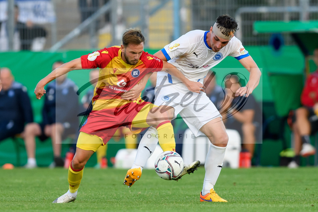 LOTKSC20210809_264 | Fussball, Herren: Lucas Cueto (Karlsruher SC) und Luis Allmeroth (Sportfreunde Lotte) im Zweikampf beim Spiel der 1. Runde im DFB-Pokal zwischen SF Lotte und Karlsruher SC im Stadion am Lotter Kreuz am 09.08.2021 in Lotte, Deutschland.DFB / DFL REGULATIONS PROHIBIT ANY USE OF PHOTOGRAPHS AS IMAGE SEQUENCES AND/OR QUASI-VIDEO. - Realisiert mit Pictrs.com