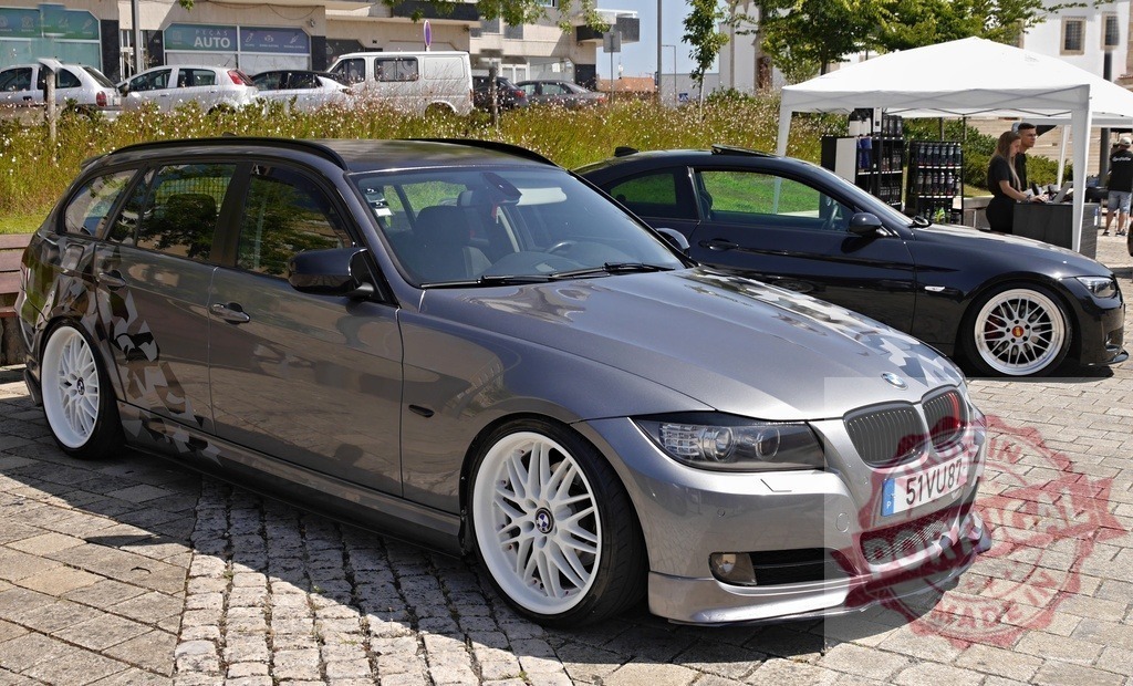 BMW E91 station wagon displaying custom modifications at car event | Grey BMW E91 station wagon with custom wheels and suspension on display at an outdoor car show - Realized with Pictrs.com