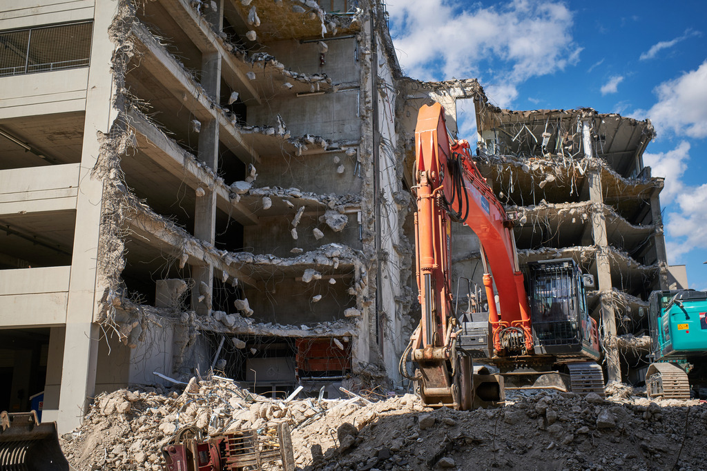 Abbruch einer Wohnanlage | Wien, Austria - May 02, 2020: Abbruch einer Wohnanlage in Floridsdorf mit einem roten Bagger. - Realisiert mit Pictrs.com