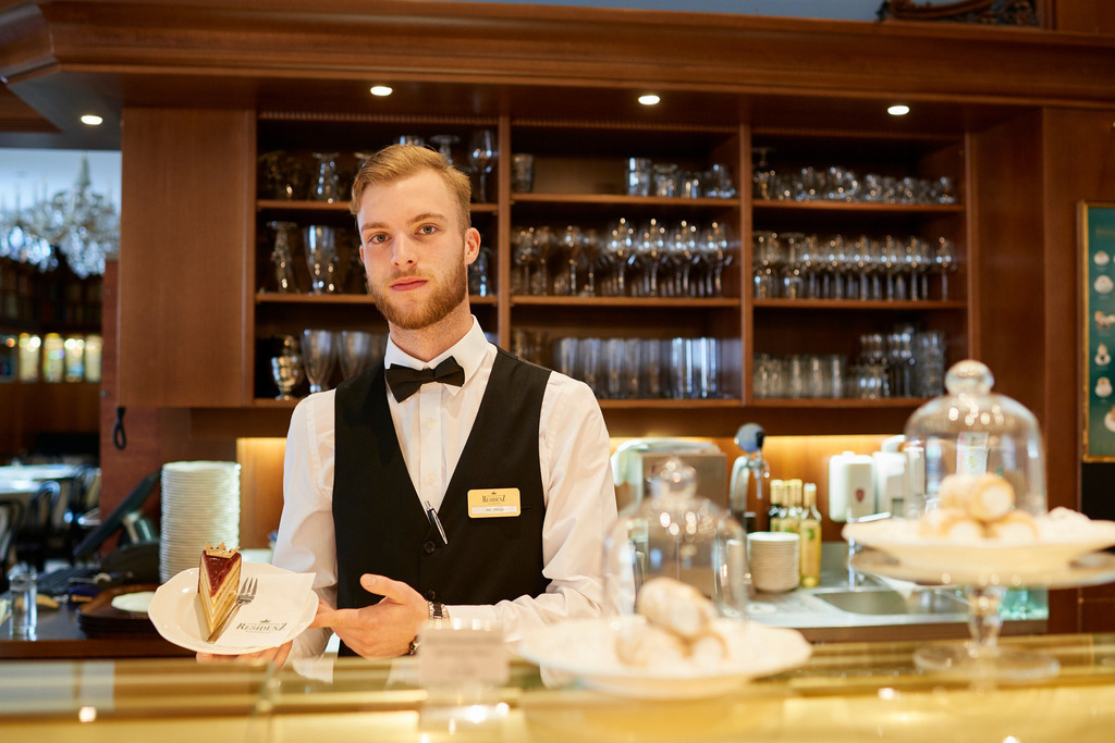 Cafe Residenz, Kellner Philip mit Schloss-Torte | Wien, Austria - August 10, 2017: Cafe Residenz, Kellner Philip präsentiert eine Schloss-Torte. - Realisiert mit Pictrs.com