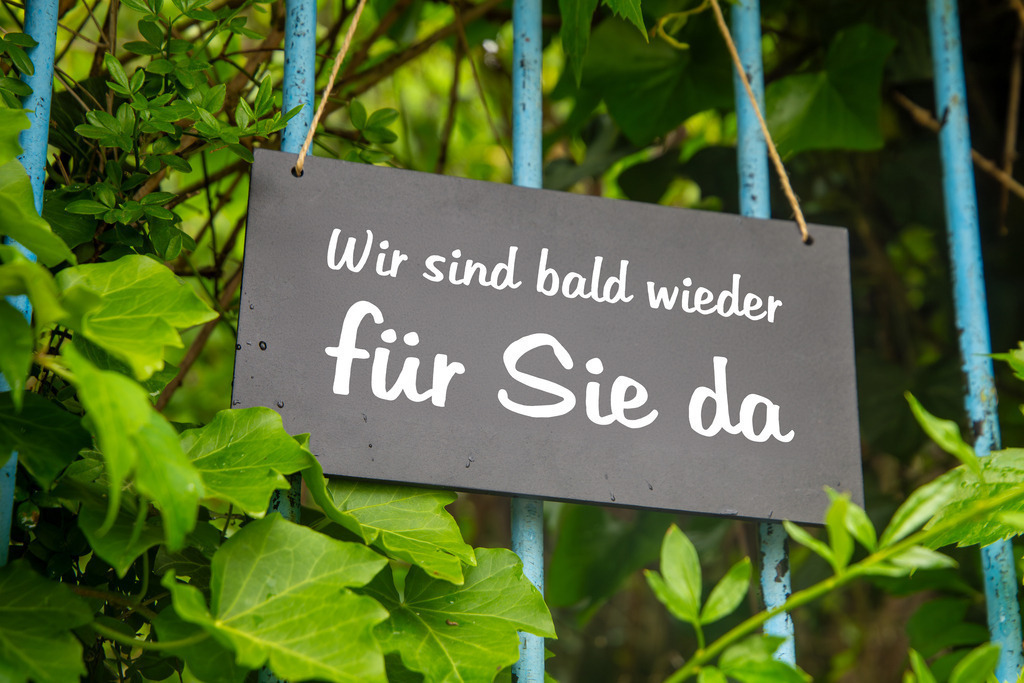Symbolbild Betriebsferien: Schild am Garten mit der Aufschrift WIR SIND BALD WIEDER FÜR SIE DA | Symbolbild Betriebsferien: Schild am Garten mit der Aufschrift WIR SIND BALD WIEDER FÜR SIE DA - Realisiert mit Pictrs.com