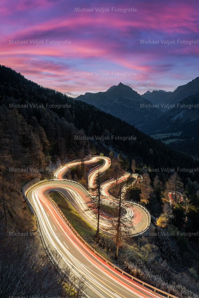 Malojapass inm Engadin am Abend | Abends beim Malojapass in der Schweiz. 148 Sekunden dauerte es in etwa, bis ein Auto die Strecke, die im Bildausschnitt zu sehen ist, den Berg hoch geschafft hat. Durch die lange Belichtungszeit erhellen die Lichter der Autos den kompletten Streckenabschnitt. Die graubündener Passstraße verbindet das Oberengadin mit dem Bergell und überwindet dabei den Alpenhauptkamm. Sie ist insgesamt 23 km lang und überwindet dabei 1.100 Höhenmeter.  - Realisiert mit Pictrs.com