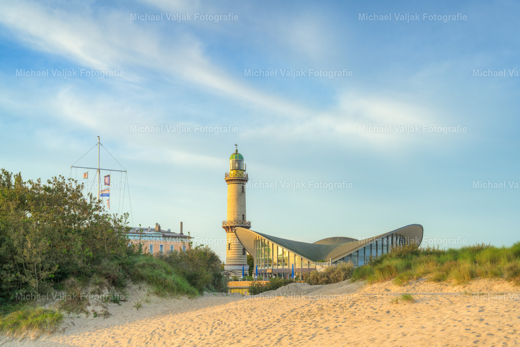 Teepott Warnemünde | Blick zum Leuchtturm Warnemünde und Teepott, einem Rundbau mit drei hyperbolischen Paraboloidschalen als Dach. Das Gebäude beherbergt ein Restaurant und ist zusammen mit dem Leuchtturm eine der bekanntesten Sehenswürdigkeiten des Ostseebad Warnemünde. - Realisiert mit Pictrs.com