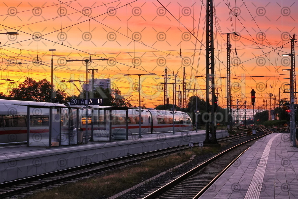 Morgengrauen am Bahnsteig | Die aufgehende Sonne bringt den Himmel über dem Bahnsteig des Dortmunder Hauptbahnhofes zum glühen. Am Gleis wartet ein ICE auf seine Fahrgäste.