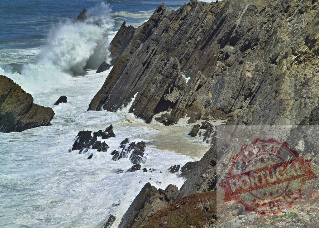Atlantic ocean waves crashing on rocky Portuguese coast | Ocean waves crashing and spewing foam against a rugged rocky cliif at the seashore - Realisiert mit Pictrs.com