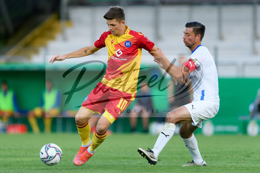 LOTKSC20210809_046 | Fussball, Herren: Marvin Wanitzek (Karlsruher SC) und Timo Brauer (Sportfreunde Lotte) im Zweikampf beim Spiel der 1. Runde im DFB-Pokal zwischen SF Lotte und Karlsruher SC im Stadion am Lotter Kreuz am 09.08.2021 in Lotte, Deutschland.DFB / DFL REGULATIONS PROHIBIT ANY USE OF PHOTOGRAPHS AS IMAGE SEQUENCES AND/OR QUASI-VIDEO. - Realisiert mit Pictrs.com