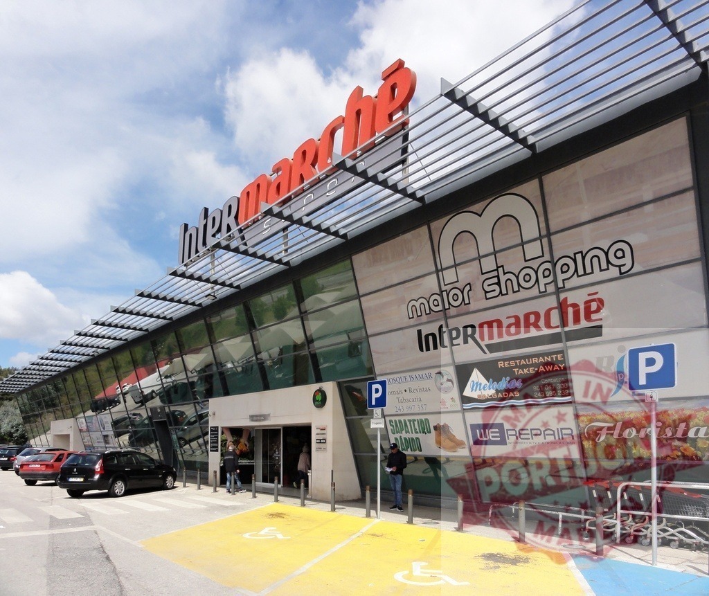 Intermarché supermarket exterior facade and retail complex | Intermarché supermarket building with Major Shopping sign, parking lot, and customers - Realized with Pictrs.com