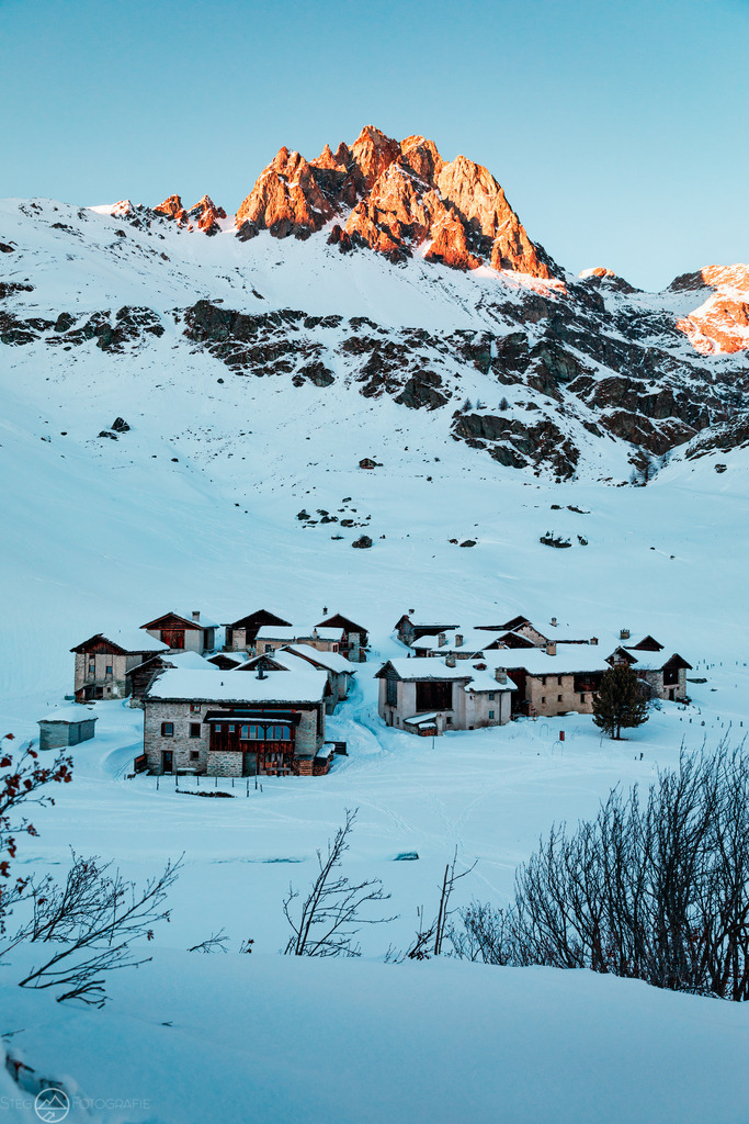 Winterdorf im Engadin | Verschneites Dorf im Engadin und vom Abendlicht erhellte FelsformationFormat 3 zu 2 - Realisiert mit Pictrs.com