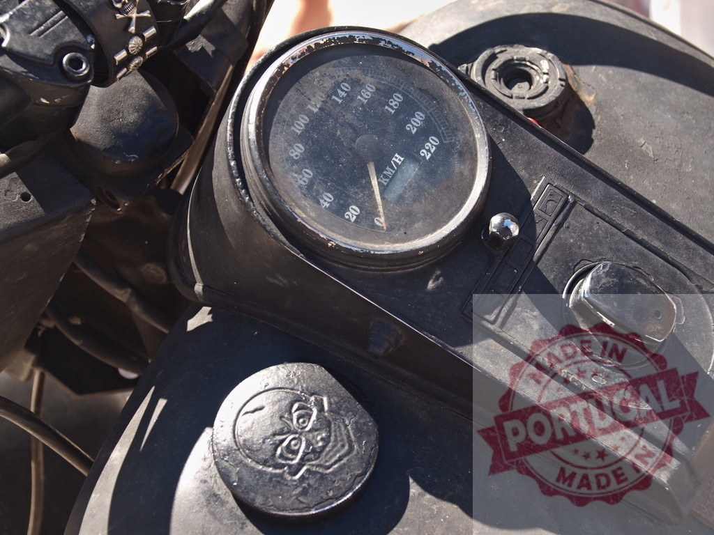 Vintage motorcycle speedometer dash with skull emblem | Close-up of a weathered custom motorcycle dashboard with a speedometer and decorative skull - Realisiert mit Pictrs.com