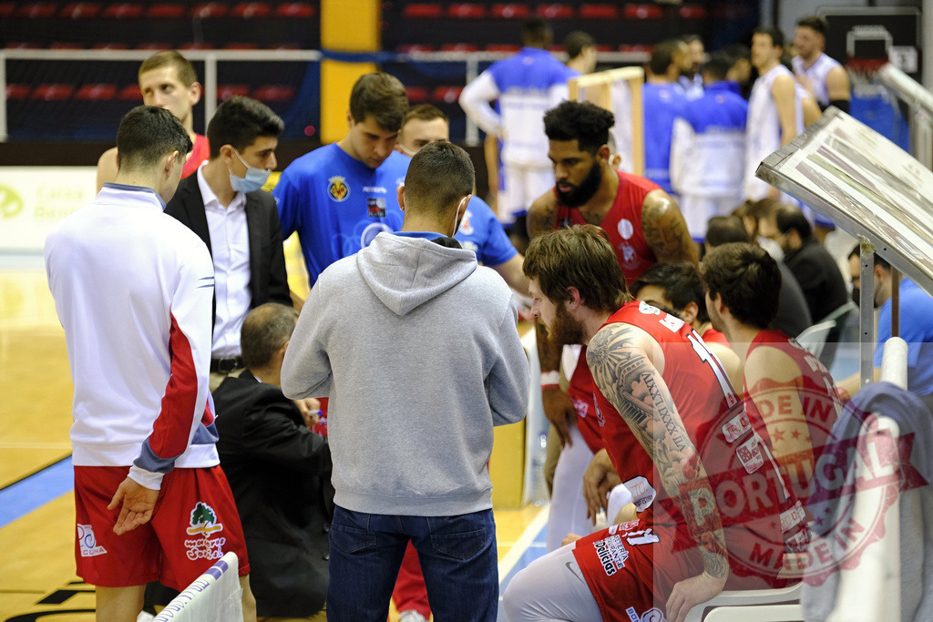 Basketball team huddling and planning strategy during game | Basketball players and coaches huddle on the sideline discussing game strategy - Realized with Pictrs.com