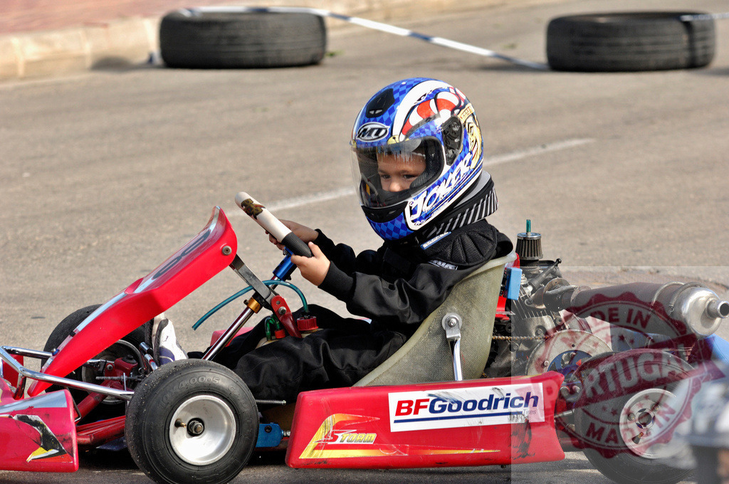 Young pilot driving go-kart on asphalt track | Young pilot concentrating driving a go-kart on a circuit - Realisiert mit Pictrs.com