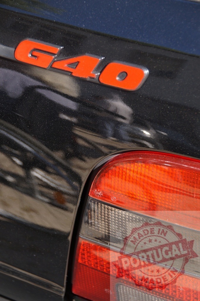Volkswagen Polo G40 red emblem and tail light | G40 emblem and car tail light on a black automotive vehicle - Realized with Pictrs.com