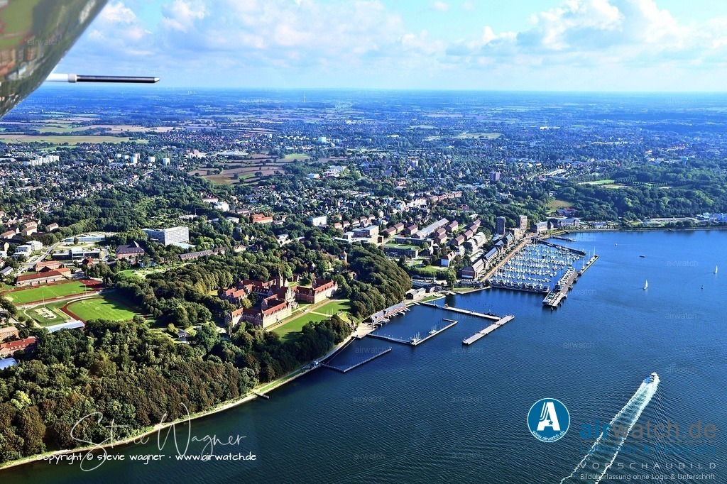 Luftbild Anflug Marineschule Muerwik - Die Marineschule Mürwik in Flensburg-Mürwik ist die zentrale Ausbildungsstätte für alle Offizieranwärter | Die Marineschule Mürwik in Flensburg-Mürwik ist die zentrale Ausbildungsstätte für alle Offizieranwärter der Deutschen Marine. Sie befindet sich in einem markanten roten Gebäudekomplex direkt am Ufer der Förde und wird daher auch als „Rotes Schloss am Meer“ bezeichnet. Hier absolvieren Marineoffiziere ihre grundlegende militärische Ausbildung, darunter theoretische Lehrgänge, praktische Seefahrtvorbereitung und Führungsübungen.