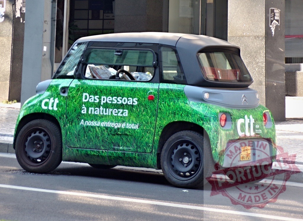 CTT Citroën Ami electric delivery car promoting sustainability | CTT Citroën Ami electric vehicle wrapped in grass livery on a city street - Realisiert mit Pictrs.com