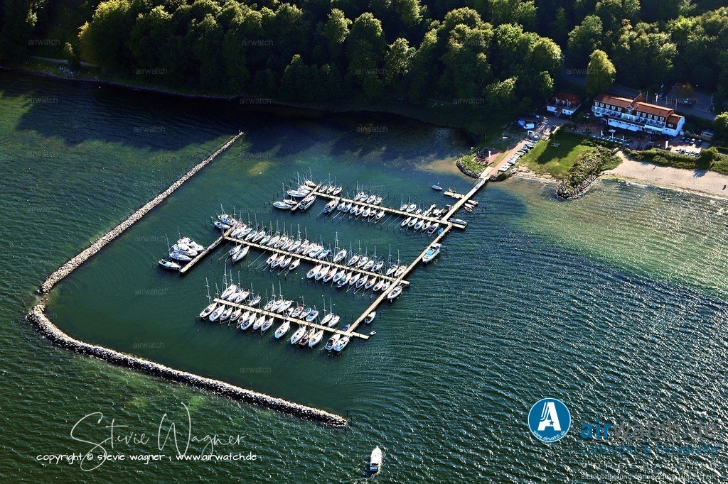 Luftbild Flensburger Foerde, Flensburg Wassersleben, Segel-Sport Flensburg Harrislee | Der Segel-Sport Flensburg-Harrislee e.V. ist ein Wassersportverein, der ursprünglich 1931 als Kanu-Sport-Flensburg gegründet wurde und seit 1990 unter dem heutigen Namen aktiv ist. Der Verein fördert den Segelsport mit Schwerpunkt auf Jugendarbeit und betreibt einen modernen Hafen mit rund 130 Liegeplätzen, der Strom und WLAN bietet.