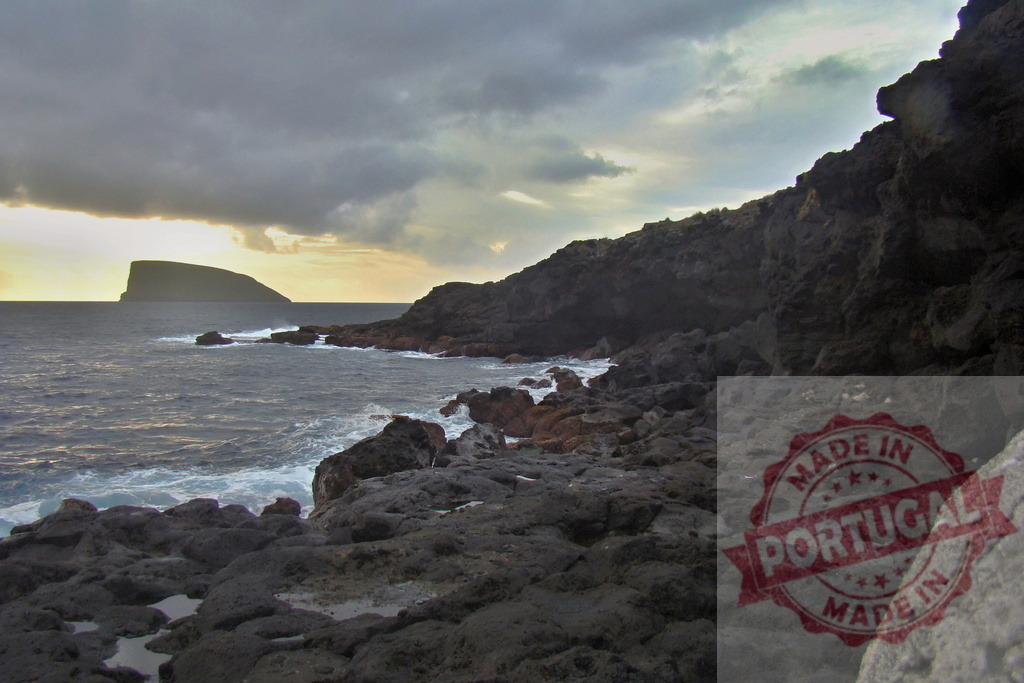 Volcanic coastline with ocean waves hitting rocks at sunset | Rugged volcanic coastline with dark rocks and ocean waves under a cloudy sunset sky - Realisiert mit Pictrs.com