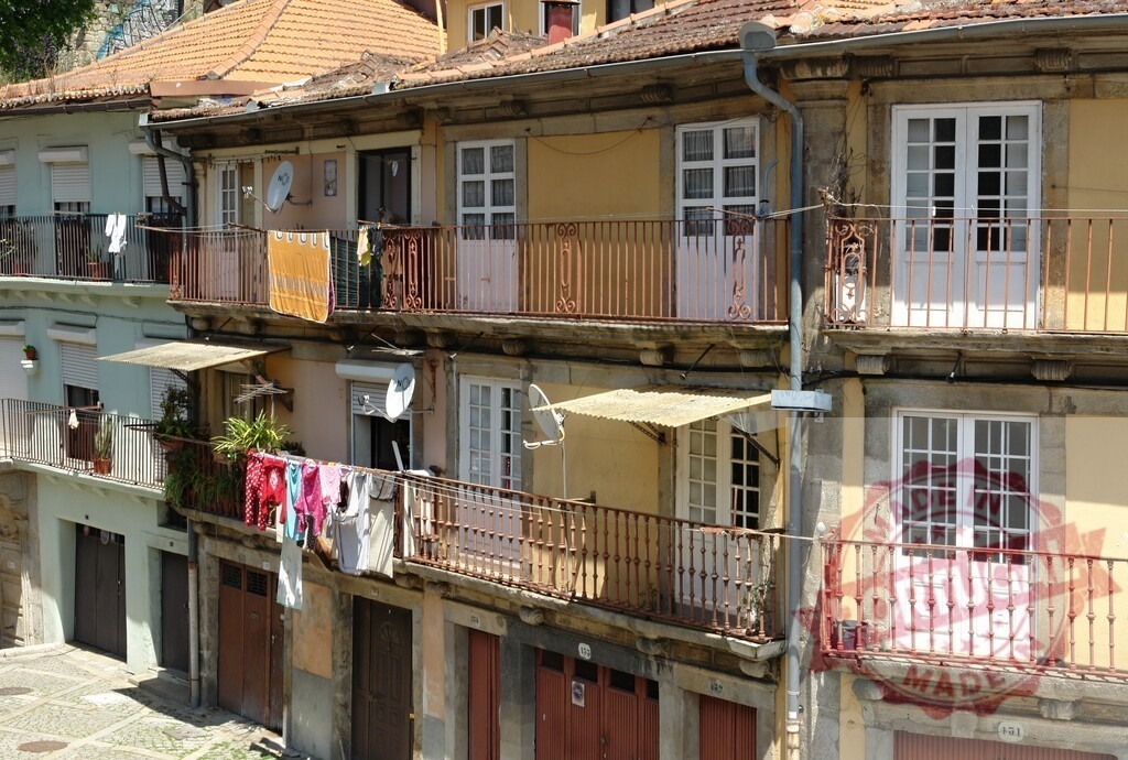 Porto, Portugal historic Ribeira district with colorful houses and laundry. Porto - Portugal | Colorful old houses with balconies and drying laundry showing daily life in Porto - Realized with Pictrs.com