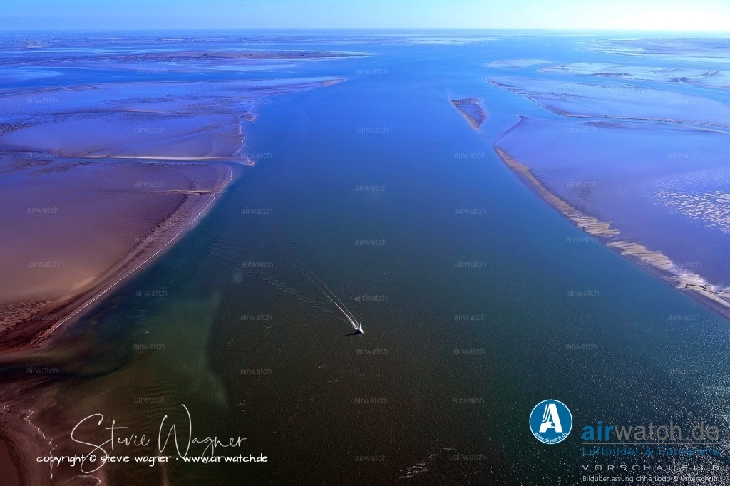 Fahrrinne und Priele zwischen Hamburger Hallig und Hallig Gröde | Fahrrinne und Priele zwischen Hamburger Hallig und Hallig Gröde im Hintergrund Nordstrandischmoor und Eiderstedt - Die Fahrrinne zwischen der Hamburger Hallig und der Hallig Gröde ist Teil des komplexen Netzwerks von Wasserwegen im nordfriesischen Wattenmeer, das durch die ständigen Veränderungen des Meeresbodens durch Gezeiten und Sturmfluten geprägt ist.