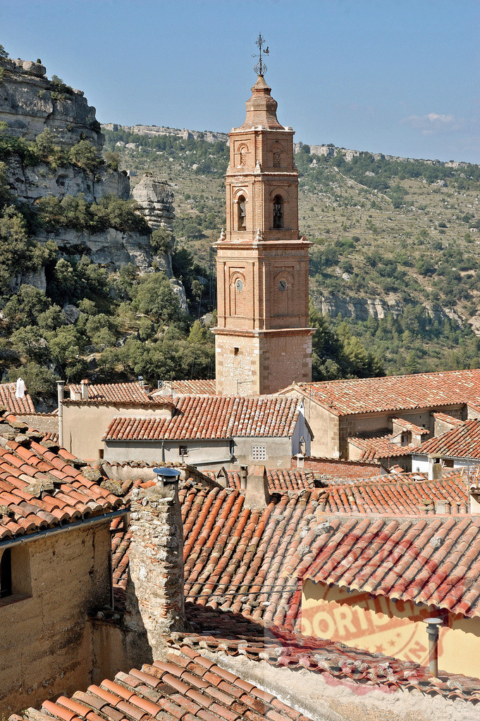 Albarracín bell tower rising above terracotta rooftops in Spain | Albarracín bell tower overseeing the historic village's rooftops among mountains - Realized with Pictrs.com