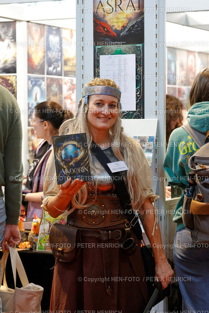 76. Frankfurter Buchmesse Impressionen | 18.10.2024 Heute ab 14 Uhr für alle geöffnet 76. Buchmesse Frankfurt Halle 1.2 New Adults hier Autorin Mira Valentin mit Buch aus der Reihe Andorin mit Titel Gottesflüstern (Foto: Peter Henrich) - Realisiert mit Pictrs.com