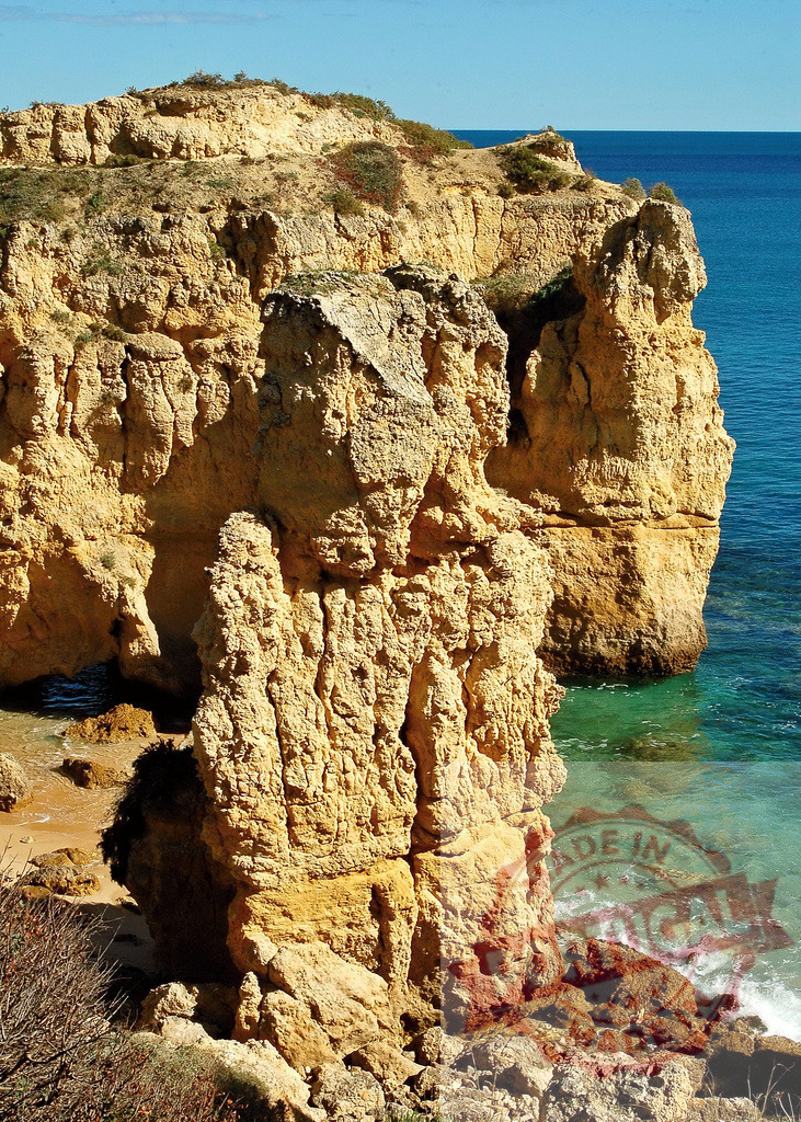 Algarve coast rugged cliffs with Atlantic ocean water | Rugged orange cliffs meeting turquoise Atlantic ocean water along the Algarve coastline - Realized with Pictrs.com