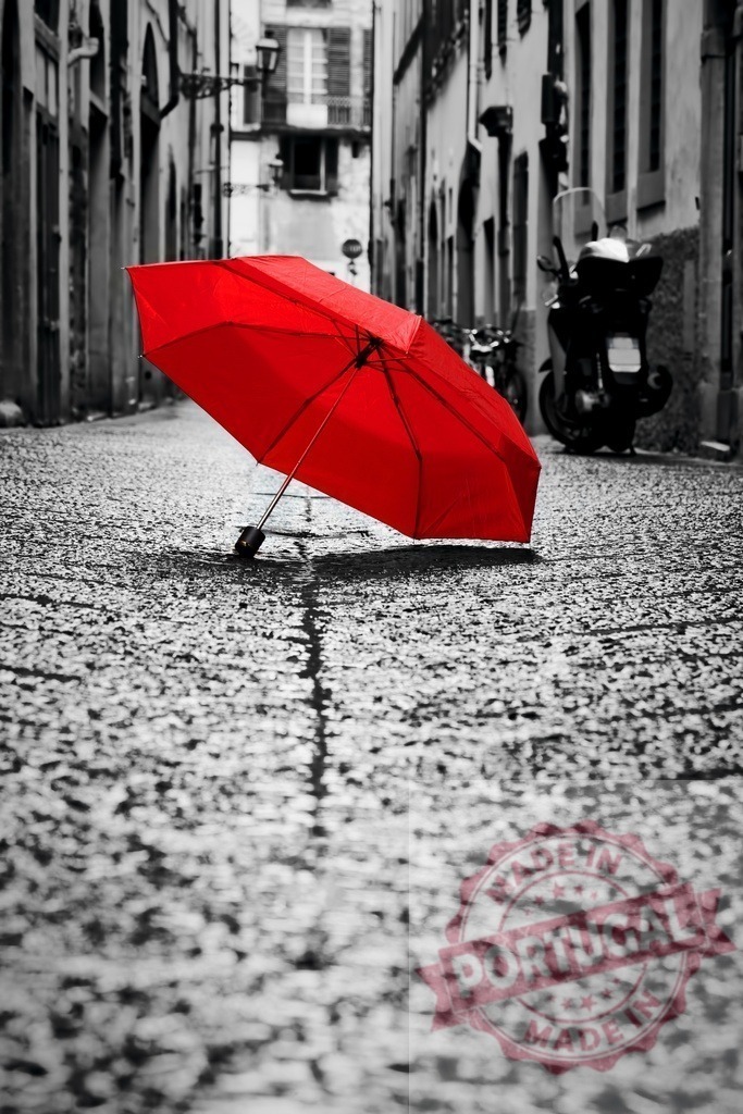Red umbrella on wet cobblestone street in Italy | Red umbrella sitting on a wet cobblestone alley in a European city, highlighting an emotional concept - Realized with Pictrs.com