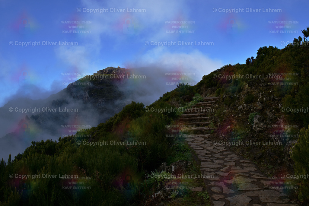 Entferntes Gipfelglück | Der Weg von der Achada do Teixeira zum Pico Ruivo ist gut mit Natursteinen befestigt .. Immer wieder ziehen Wolken auf und verdecken die Sicht. In der ferne sieht am Wanderer auf dem Pico Ruivo