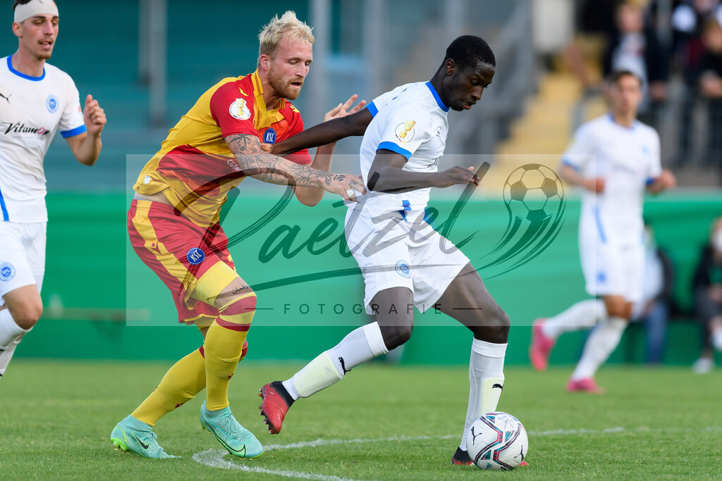 LOTKSC20210809_039 | Fussball, Herren: Philipp Hofmann (Karlsruher SC) und Komlan Fionouke (Sportfreunde Lotte) im Zweikampf beim Spiel der 1. Runde im DFB-Pokal zwischen SF Lotte und Karlsruher SC im Stadion am Lotter Kreuz am 09.08.2021 in Lotte, Deutschland.DFB / DFL REGULATIONS PROHIBIT ANY USE OF PHOTOGRAPHS AS IMAGE SEQUENCES AND/OR QUASI-VIDEO. - Realisiert mit Pictrs.com