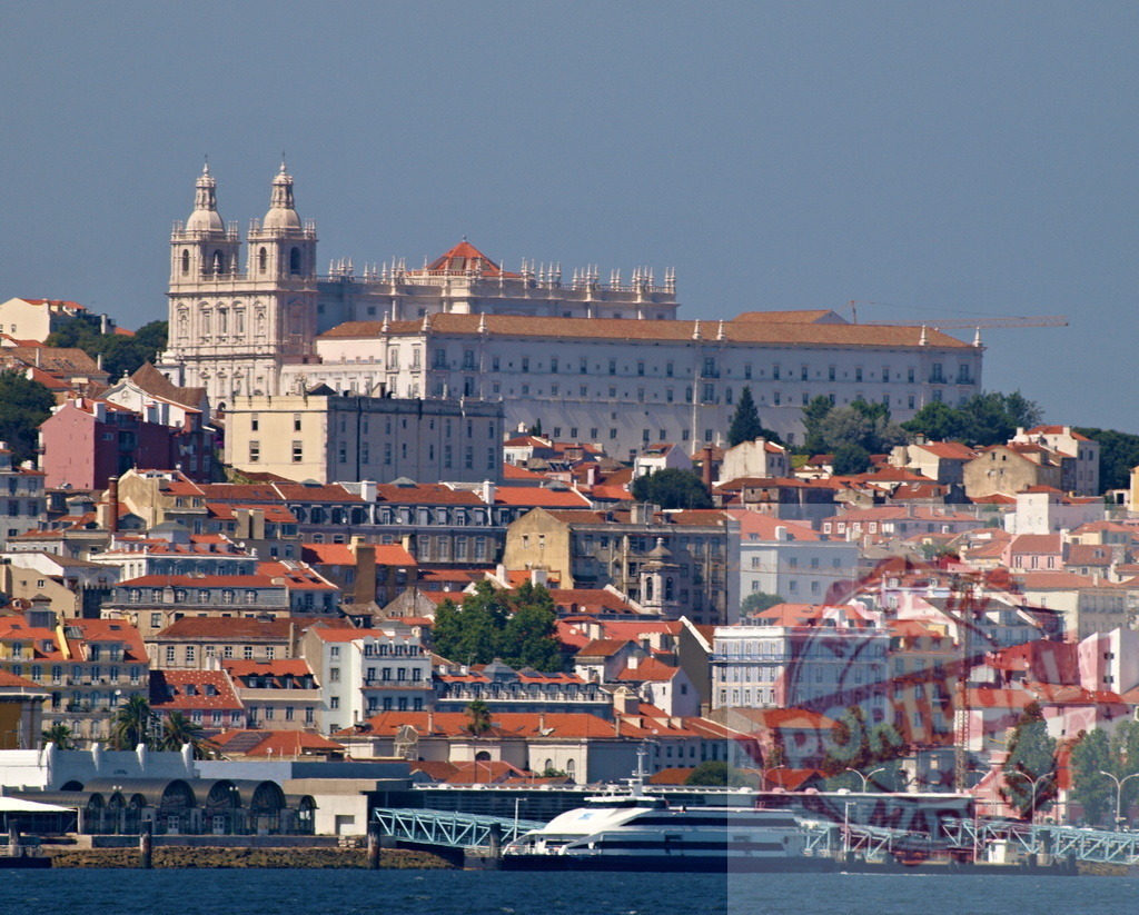 Lisbon city skyline by Tagus river. Lisbon - Portugal | Lisbon cityscape with traditional buildings, the Church of São Vicente de Fora, and a ferry on Tagus river - Realized with Pictrs.com