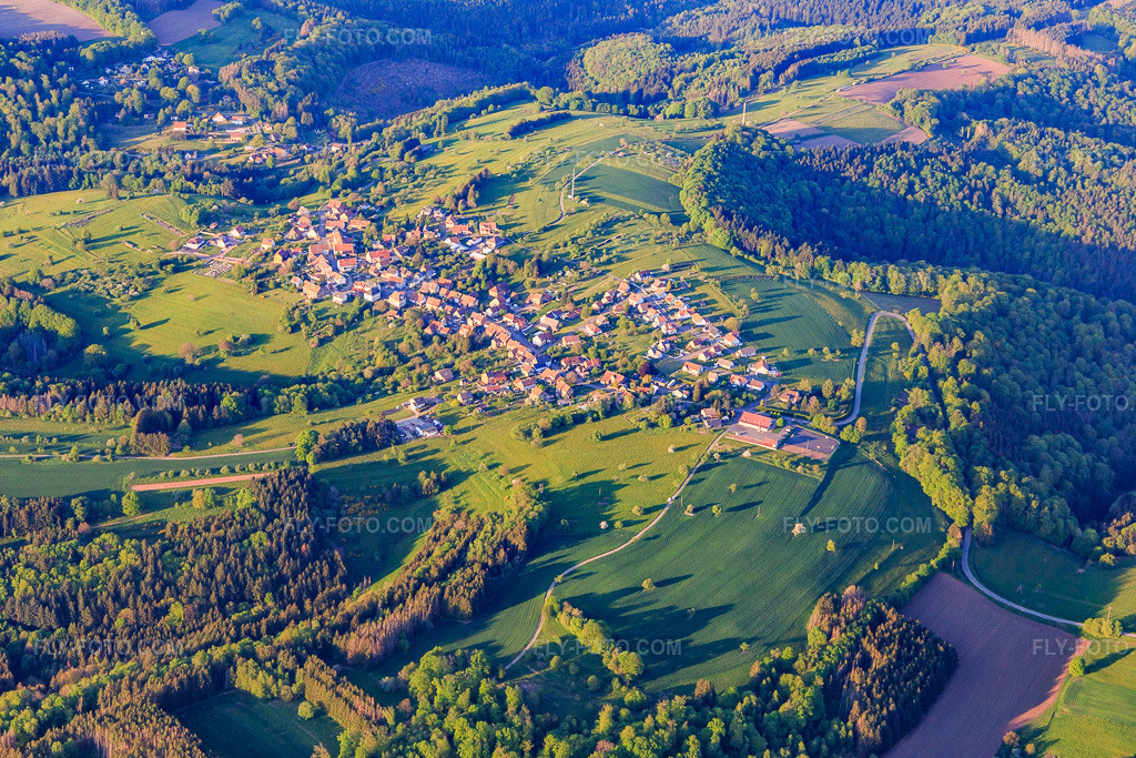 Aerial view: Village view in the Northern Vosges Mountains from the southwest in Puberg in the state Bas-Rhin, France. – Photo: IMG_145839.jpg taken on 04/30/2025 by Werner Riehm/FLY-FOTO.com – Resolution of the original: 5472 x 3648 px
